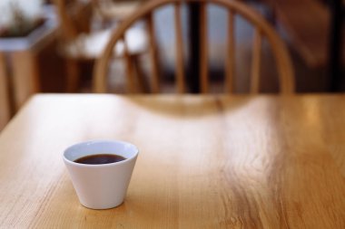 Tahta bir masada bir fincan kahve..