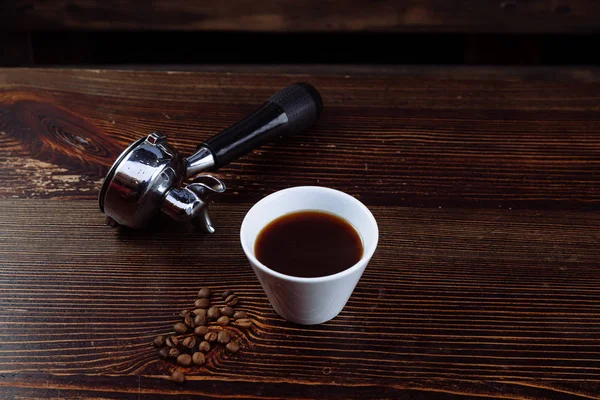 Eine Tasse schwarzen Kaffee und Filterhalter für Espresso. — Stockfoto