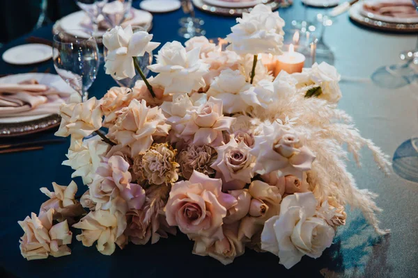 Festliche Tischdekoration mit einem Blumenstrauß und Kerzen. — Stockfoto