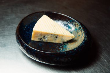 Bir parça küflü peynir tabakta yatıyor..