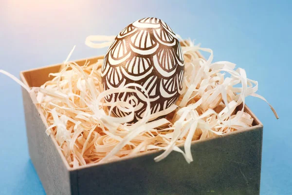 The Easter egg is painted in black and white, an abstraction, lies in a box. — Stock Photo, Image