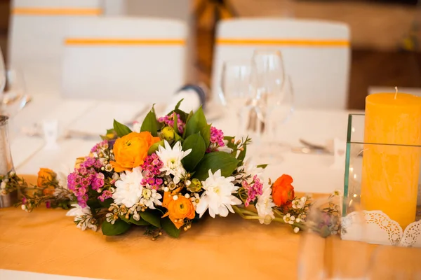 Ünnepi asztalterítés virágcsokorral és gyertyákkal. — Stock Fotó
