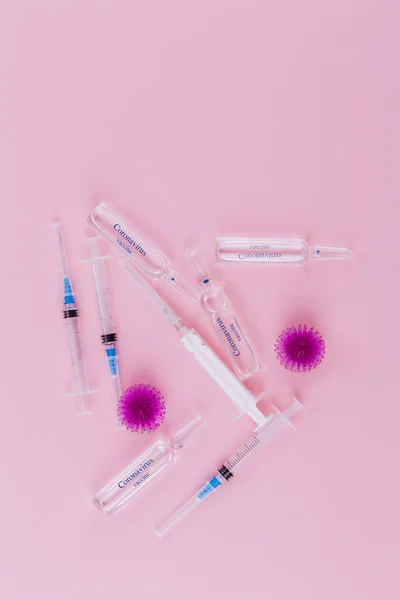 Rode virus, spuit en ampullen met geneesmiddel op een roze achtergrond. — Stockfoto