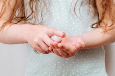 Çocuk el dezenfektanı kullanıyor..