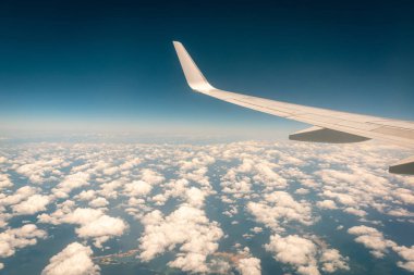 Gün batımında bulutların üzerinde uçan uçak.