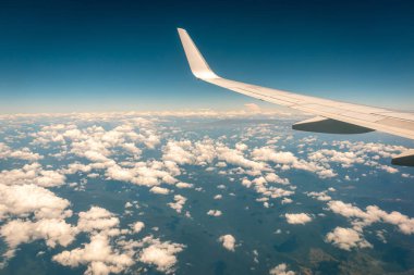 Gün batımında bulutların üzerinde uçan uçak.