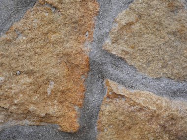 Taş ve çimento desenli duvar kağıdı farklı kahverengi ve gri tonlarda.