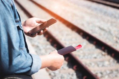 Tren istasyonunda pasaportlu akıllı telefon kullanarak el gezgini kapat..