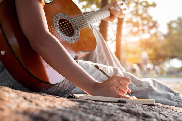 Songwriter Schreibt Auf Notizbuch Mit Akustikgitarre — Stockfoto