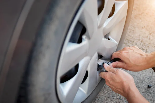 Close up hand of man inflating tire.