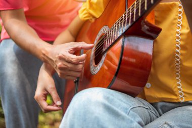 Adam kız arkadaşına gitar çalmayı öğretiyor..