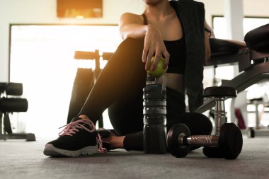 Spor salonunda spor yaptıktan sonra elinde su tutan kadın. Sağlıklı ve yaşam tarzı kavramı.