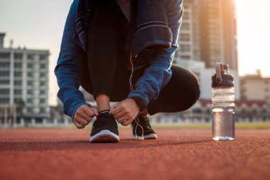 Koşucu kadın ayakkabı bağcıklarını bağlıyor..