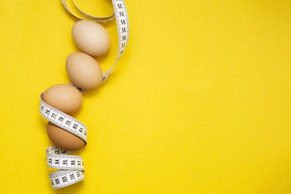 Grön kost ägg mäta på gul bakgrund. Friska livsstil koncept. Ketogen kost koncept. Hälsosam kost koncept. Matlagning middag. Mätbegrepp. — Stockfoto