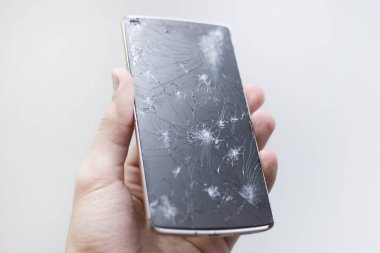 Kırık ekran ile cep telefonu tutan adam el