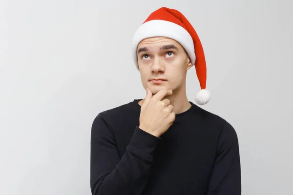 Noel Baba şapkalı adam, tatilleri düşünüyor. Ciddi bir yüz ve bakış..