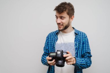 Genç fotoğrafçı fotoğraf çekiyor. Gri renkte izole edilmiş.