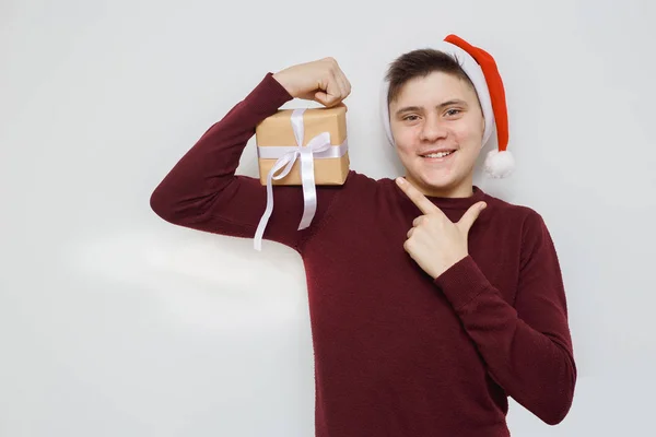 Noel Baba şapkalı bir genç. Mutlu ergenlik tatili için hazır olumlu ifadeleri olan, beyaz arka planda izole edilmiş.