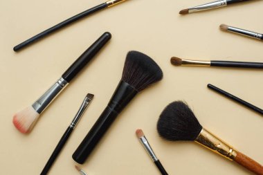 Çeşitli kadın makyaj malzemeleriyle çeşitli yüz fırçaları. Düz yatıyordu 