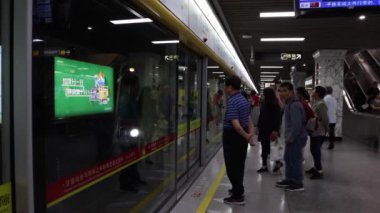Guangzhou, Çin - 07 Kasım 2019: Martin 's Park metro istasyonu. İnsanlar durup metroyu bekliyor. Metro gelir, kapılar açılır ve insanlar metroya biner..