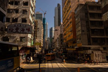 Hong Kong, China - November 25, 2019: Central streets of Hong Kong. Taxis, buses, and trams go down the street. People walk along the sidewalk