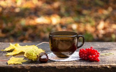 Sonbahar atmosferli ahşap bir yüzeyde bir fincan çay.