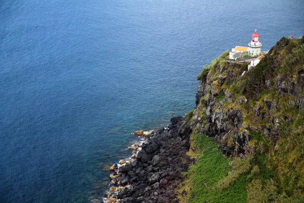 The white and red lighthouse on the green cliff — Stock Photo, Image