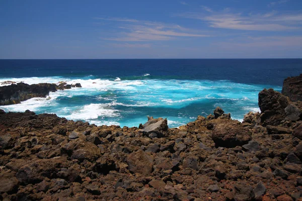 Das intensive blaue Meer und die schwarzen vulkanischen Felsen — Stockfoto