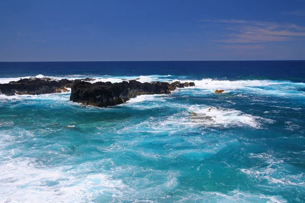 Η έντονη γαλάζια θάλασσα και τα μαύρα ηφαιστειακά πετρώματα — Φωτογραφία Αρχείου