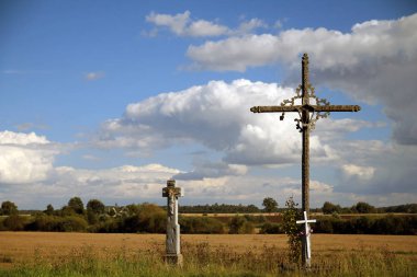 Çayırda bulutlarla birlikte iki haç