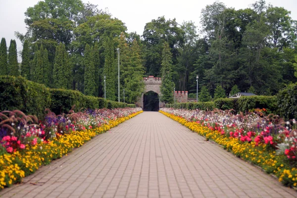 Nowa brama Sigulda z kolorowymi kwiatami — Zdjęcie stockowe