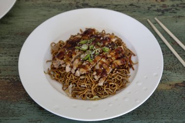 Klasik ahşap arka planda teriyaki tavuklu yakisoba eriştesi. Asya yemekleri