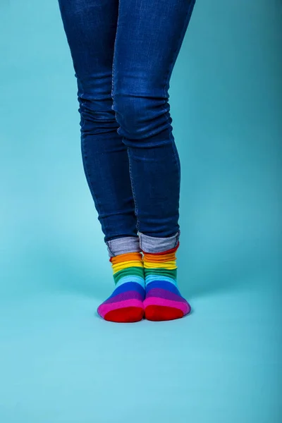 Жінка в блакитних джинсах з Lgtbi кольоровими шкарпетками на синьому фоні. Ізольоване зображення . — стокове фото