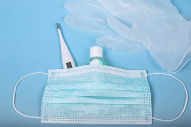 Tedavi için kişisel hijyen ve koruma ürünleri. Cerrahi maske, termometre, dezenfekte jeli ve lateks eldiven. Coronavirus ya da Cvid-19 konsepti. Dünya virüsü