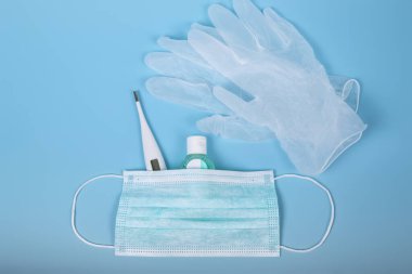Tedavi için çok önemli kişisel hijyen ve koruma ürünleri. Cerrahi maske, termometre, dezenfekte jeli ve lateks eldiven. Coronavirus ya da Cvid-19 konsepti. Dünya virüsü