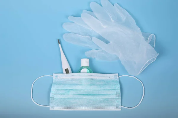 Tedavi için çok önemli kişisel hijyen ve koruma ürünleri. Cerrahi maske, termometre, dezenfekte jeli ve lateks eldiven. Coronavirus ya da Cvid-19 konsepti. Dünya virüsü