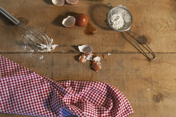 flour and egg, preparation of the dough. Ingredients for the dough: eggs and flour with a whisk on wooden background. Top view