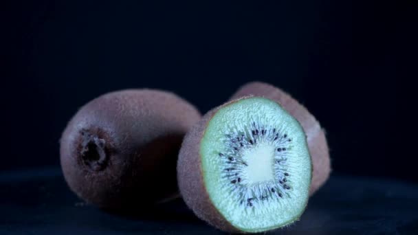 Frische Kiwi Früchte Halbiert Auf Schwarzem Hintergrund — Stockvideo