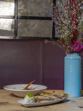 Restoranda servis edilen yemekler ahşap masa ve vazoda menü olarak sunuluyor..