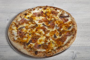 Tahta arka planda karamelli soğanlı zanaatkar biftekli pizza. Menü kartı resmi