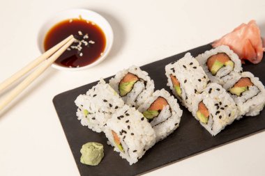 Beyaz arka planda Urimaki somonu ve avokado tabakasının izole edilmiş görüntüsü