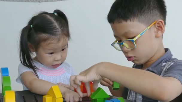 Kinder spielen mit bunten Bauklötzen — Stockvideo