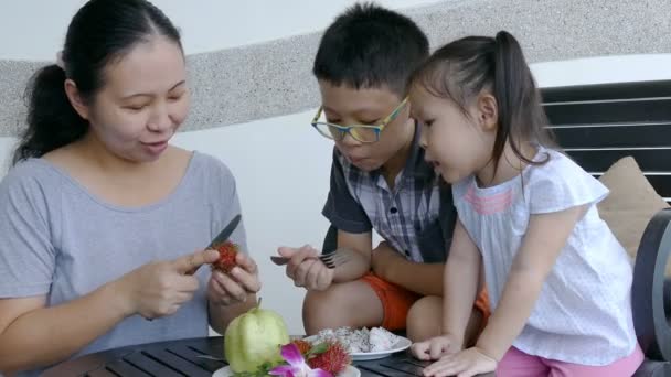 Syskon och mamma äta frukt tillsammans — Stockvideo