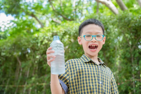 公園で飲む水のボトルを保持している少年 — ストック写真