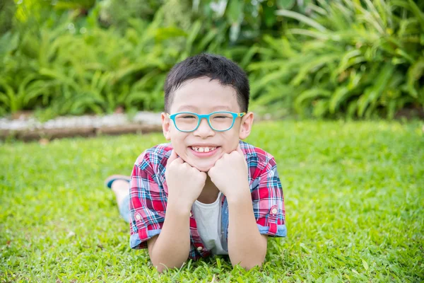 Junge liegt auf Wiese und lächelt — Stockfoto
