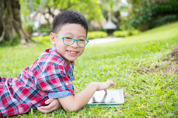 Chłopiec przy użyciu komputera typu tablet w parku — Zdjęcie stockowe