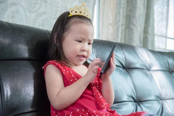 Oturan kız oyunlarını akıllı telefon — Stok fotoğraf