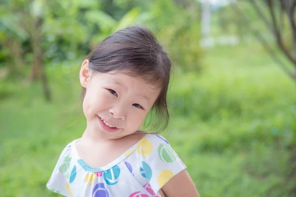 Маленькая девочка улыбается в парке — стоковое фото