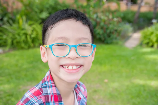 Junge sitzt auf Wiese und lächelt — Stockfoto