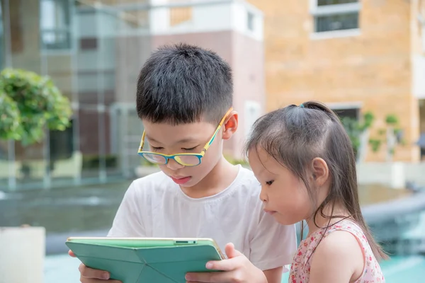 Erkek ve kız bir tablet bilgisayar kullanarak — Stok fotoğraf